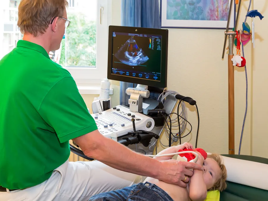 Dr. med. Eberhard Griese untersucht ein Kind - Kinderkardiologische Gemeinschaftspraxis